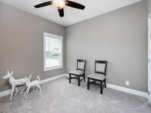 sitting room with a ceiling fan, baseboards, and carpet flooring