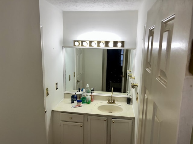 bathroom featuring a textured ceiling and vanity