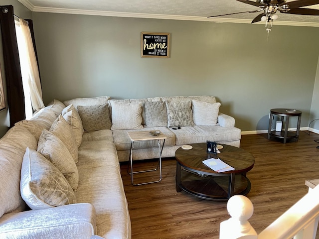 living area featuring a ceiling fan, baseboards, ornamental molding, and wood finished floors