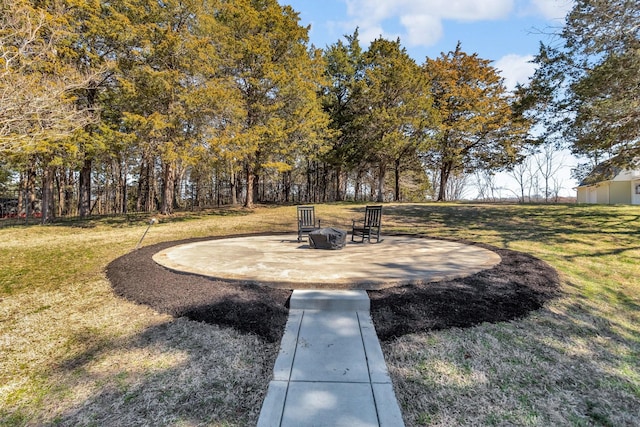 view of community with a yard, a fire pit, and a patio