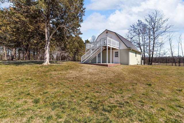 rear view of house with a gambrel roof, stairway, metal roof, a yard, and a wooden deck