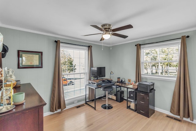 home office with a ceiling fan, wood finished floors, visible vents, and crown molding