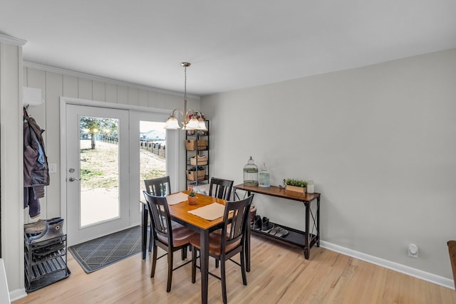 dining space with a chandelier, baseboards, and wood finished floors