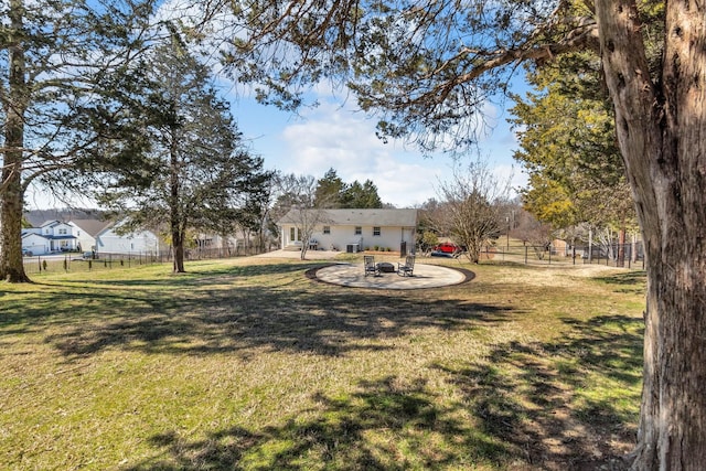 view of yard with a fire pit, a patio area, and fence