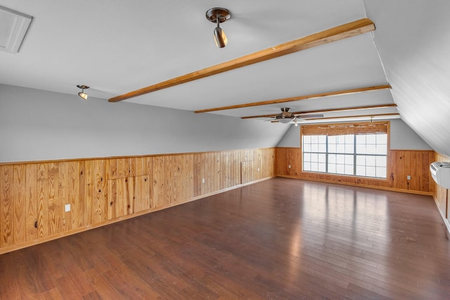 additional living space with a wainscoted wall, lofted ceiling with beams, and hardwood / wood-style floors