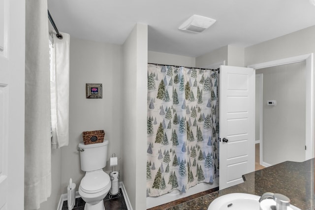 bathroom with toilet, curtained shower, visible vents, and a sink