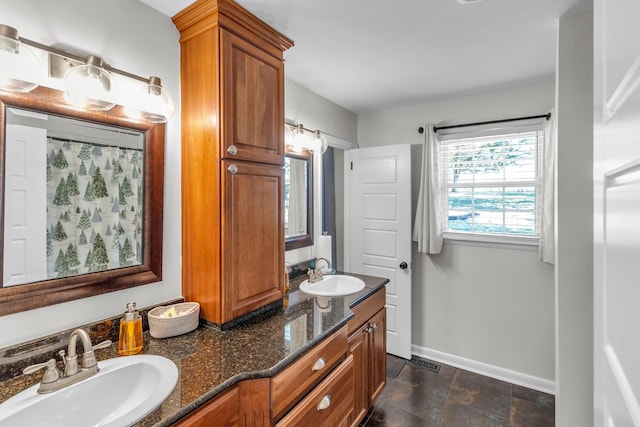 full bath featuring visible vents, a sink, baseboards, and double vanity