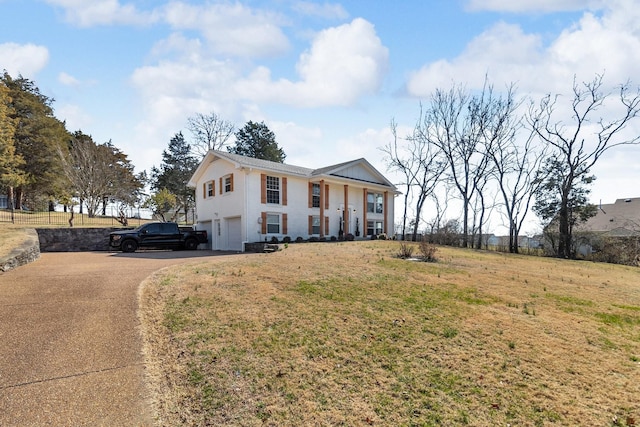 view of front facade with a garage, stucco siding, aphalt driveway, and a front yard