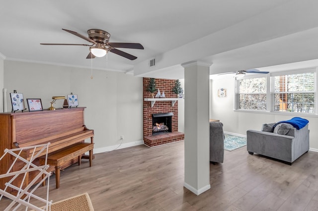 sitting room with ornamental molding, wood finished floors, and a ceiling fan