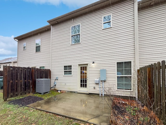 back of property with cooling unit, a patio, and fence