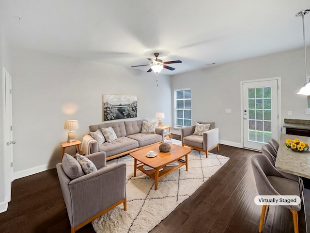 living area with dark wood-style floors, ceiling fan, and baseboards