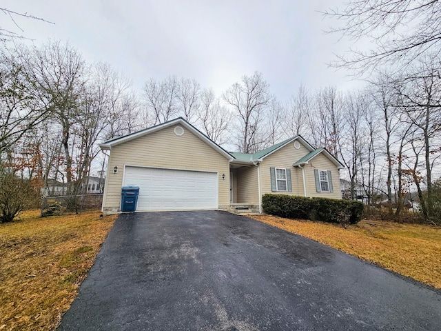 single story home featuring aphalt driveway and an attached garage