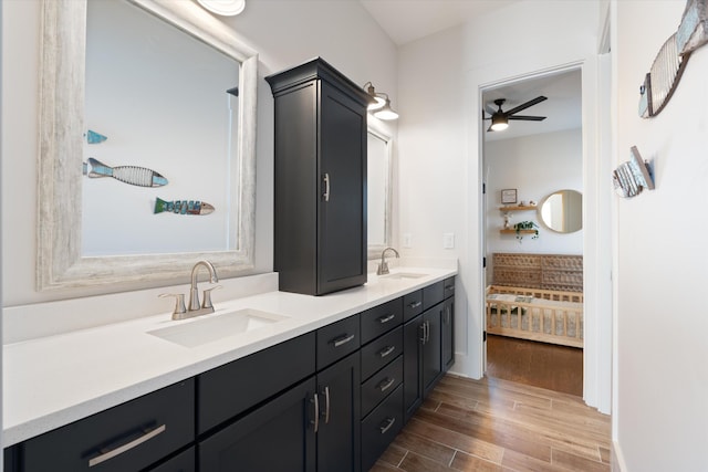 full bath featuring ensuite bathroom, double vanity, wood finished floors, and a sink