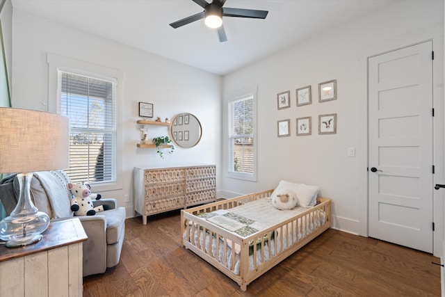 bedroom with multiple windows, wood finished floors, a ceiling fan, and baseboards