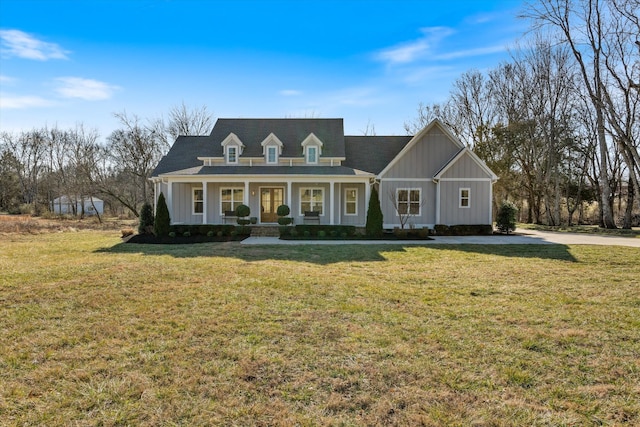 view of front of house featuring board and batten siding, a front yard, and covered porch