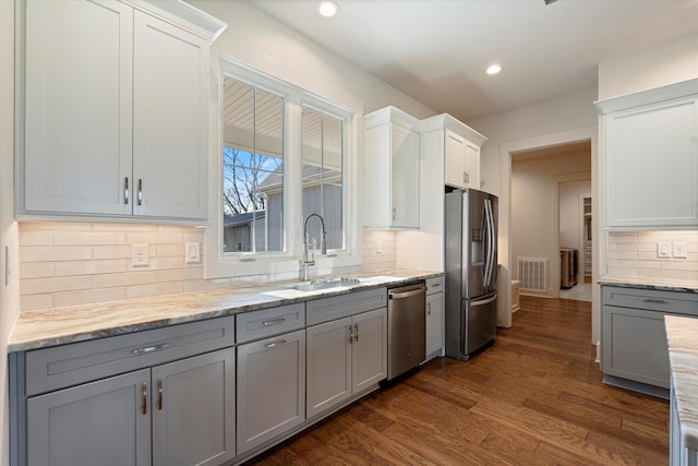 kitchen with recessed lighting, dark wood-type flooring, a sink, appliances with stainless steel finishes, and gray cabinets