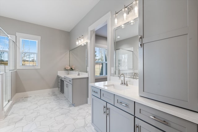 bathroom with a stall shower, baseboards, a sink, marble finish floor, and two vanities