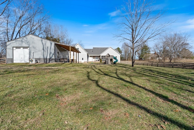 view of yard with an outbuilding, a pole building, and fence