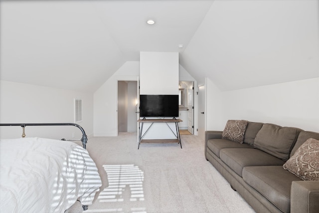 bedroom with vaulted ceiling, visible vents, and light colored carpet