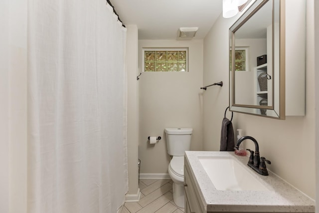 bathroom with a shower with shower curtain, toilet, vanity, wood finished floors, and baseboards