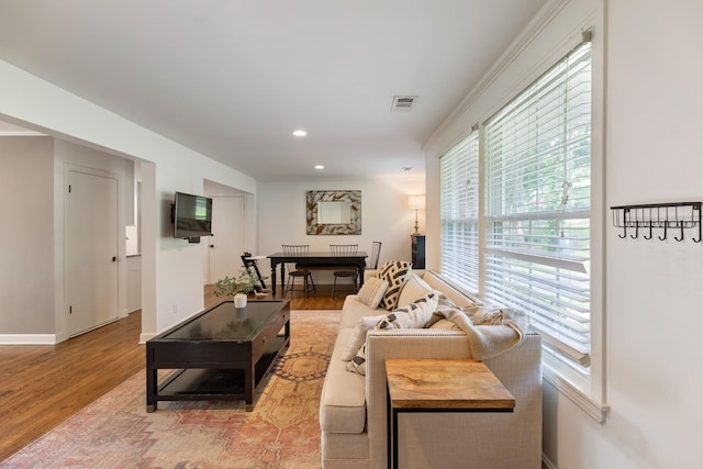 living room with baseboards, light wood-type flooring, visible vents, and recessed lighting