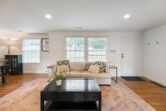 living room with ornamental molding, recessed lighting, visible vents, and wood finished floors