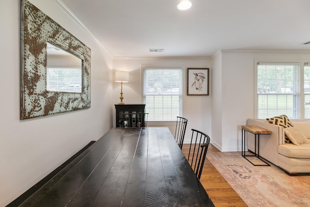 dining room featuring ornamental molding, wood finished floors, visible vents, and baseboards