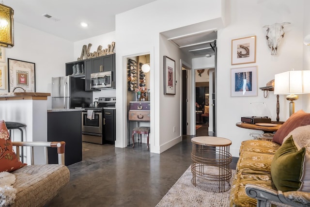 living area with baseboards, visible vents, concrete flooring, and recessed lighting