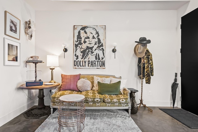 sitting room featuring concrete floors and baseboards