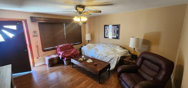 living area featuring ceiling fan, baseboards, and wood finished floors