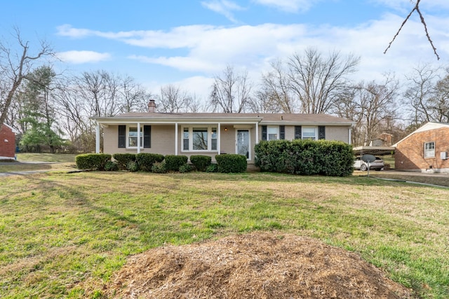 view of front of house with a front yard, brick siding, and a chimney