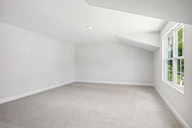 bonus room featuring lofted ceiling, carpet, and baseboards