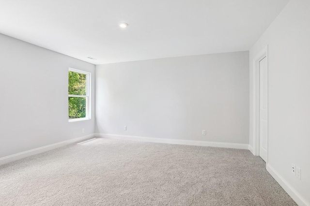 empty room featuring baseboards and carpet flooring