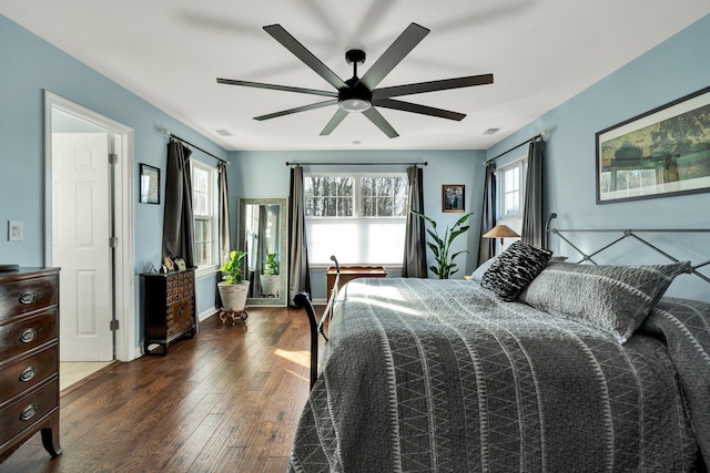 bedroom with dark wood-style floors, a ceiling fan, and baseboards