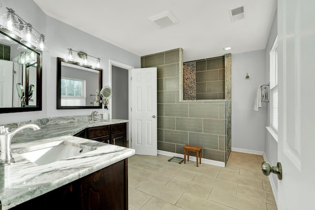 full bath with double vanity, visible vents, a sink, walk in shower, and tile patterned floors