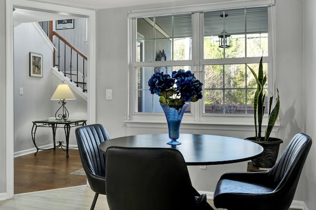 dining space featuring stairs, baseboards, and wood finished floors