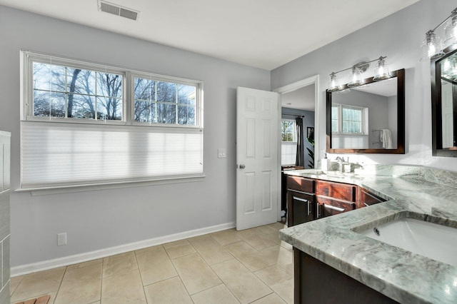 full bath featuring double vanity, tile patterned flooring, visible vents, and a sink