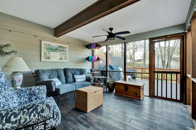 sunroom / solarium featuring ceiling fan and beam ceiling