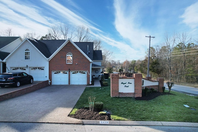 exterior space with aphalt driveway, a front yard, brick siding, and an attached garage