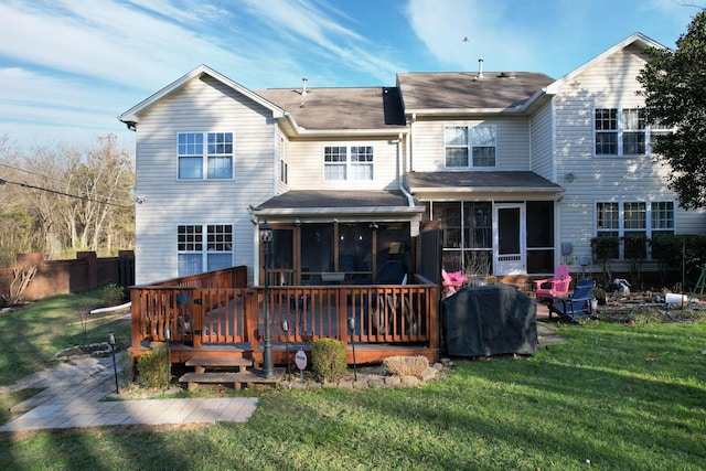 rear view of property with a sunroom, a wooden deck, and a yard