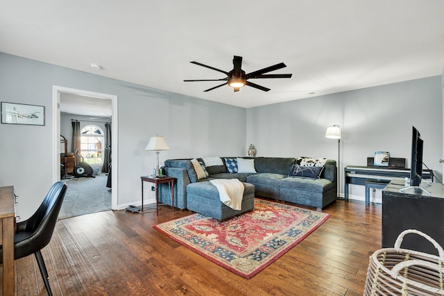 living room with dark wood-style floors, baseboards, and a ceiling fan