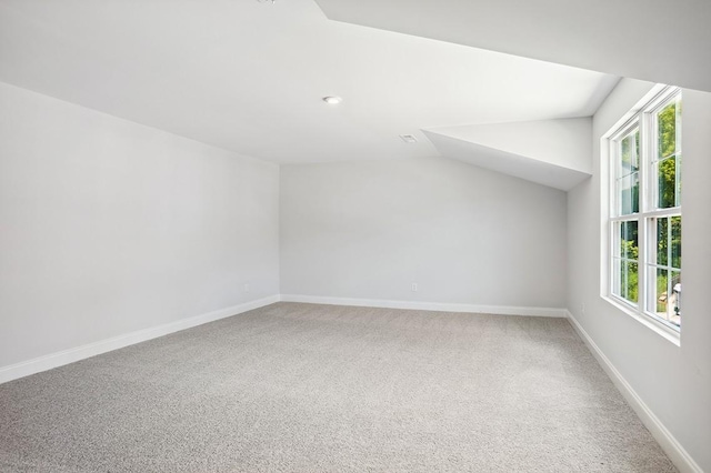 additional living space featuring vaulted ceiling, carpet, and baseboards