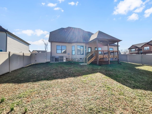 rear view of property featuring stairway, a lawn, a fenced backyard, and a wooden deck