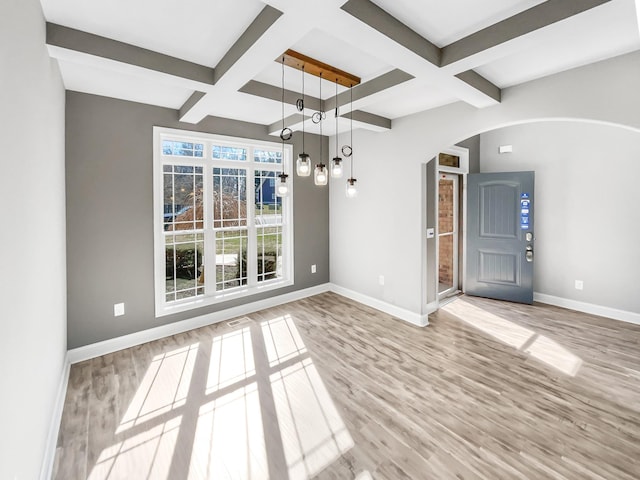 interior space featuring arched walkways, coffered ceiling, wood finished floors, and baseboards