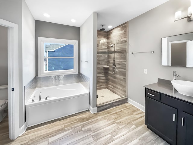 full bath featuring baseboards, toilet, vanity, a shower stall, and a bath