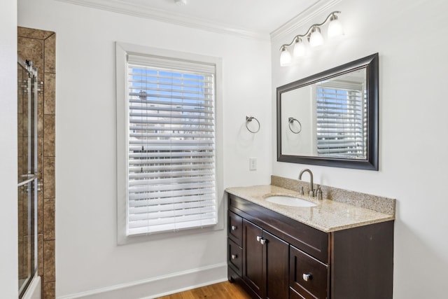 bathroom featuring crown molding, a shower with door, vanity, wood finished floors, and baseboards