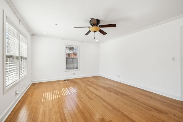 unfurnished room with light wood finished floors, ornamental molding, and baseboards