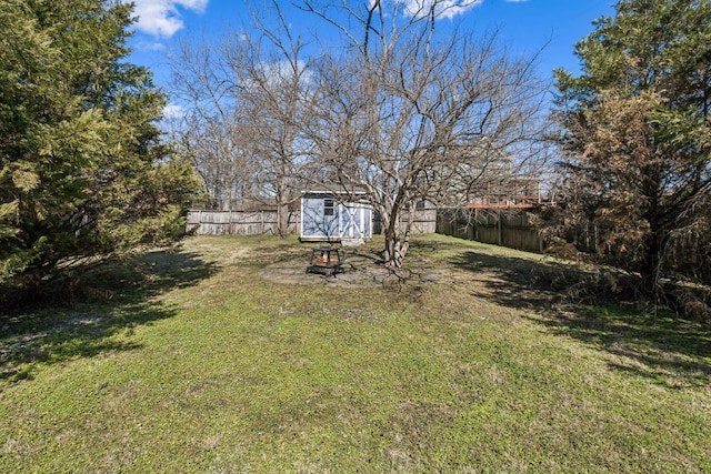 view of yard featuring a storage unit, an outdoor structure, and a fenced backyard