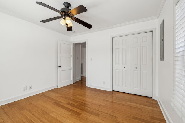 unfurnished bedroom featuring light wood-style floors, baseboards, and crown molding