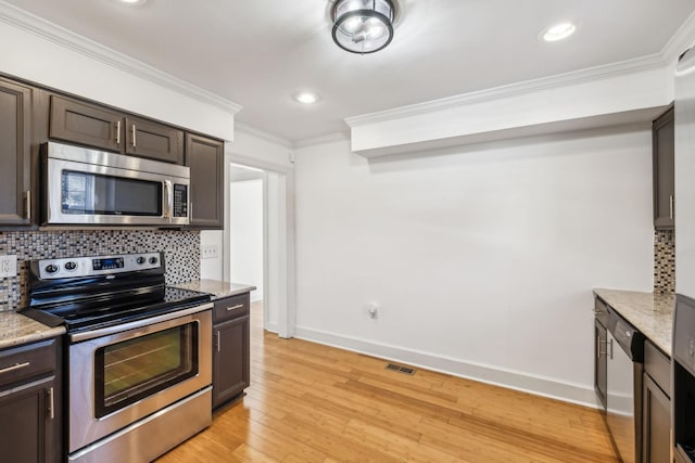 kitchen with dark brown cabinetry, decorative backsplash, appliances with stainless steel finishes, ornamental molding, and light wood-type flooring